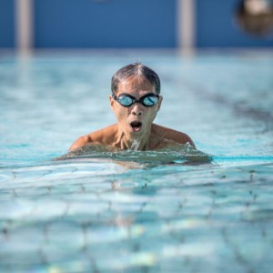 Elderly man swimming in pool